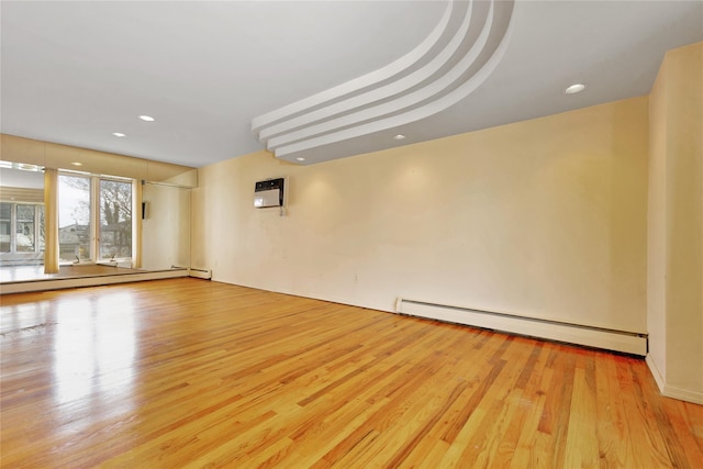 9 Ensign Dr, Massapequa, NY 11758 - spare room with a baseboard heating unit, wood finished floors, baseboard heating, and a wall mounted AC