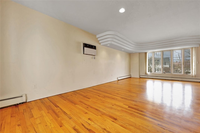 9 Ensign Dr, Massapequa, NY 11758 - spare room featuring a baseboard heating unit, wood finished floors, and a wall mounted AC