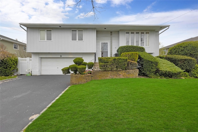9 Ensign Dr, Massapequa, NY 11758 - bi-level home featuring fence, driveway, brick siding, a front yard, and a garage