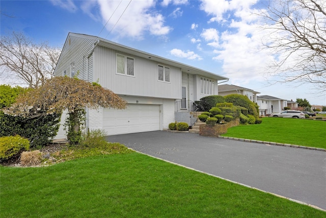 9 Ensign Dr, Massapequa, NY 11758 - split foyer home featuring a front lawn, aphalt driveway, brick siding, and a garage