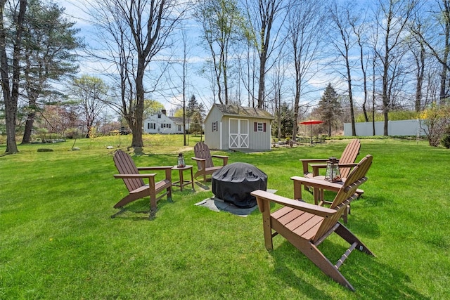 view of yard with an outdoor fire pit, a shed, and an outbuilding