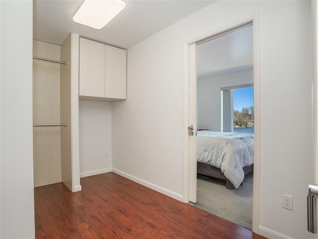 unfurnished bedroom featuring baseboards and dark wood-style floors