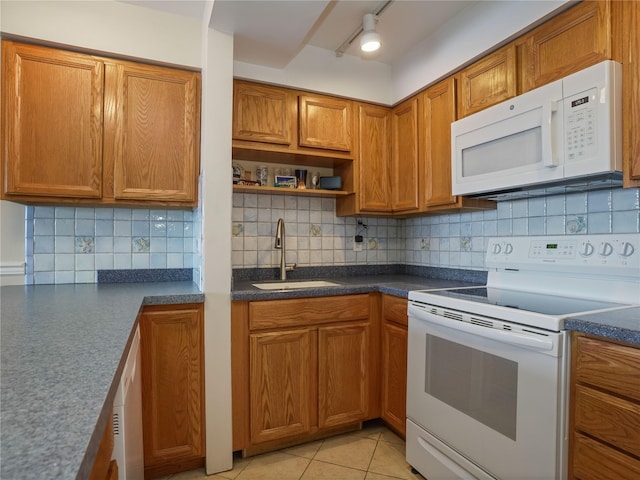 kitchen featuring a sink, backsplash, white appliances, and brown cabinets