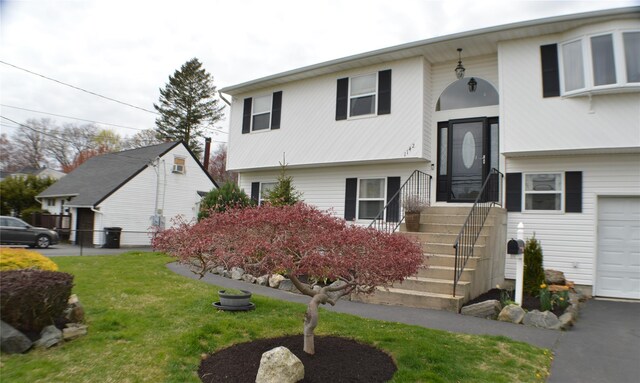 split foyer home featuring fence and a front lawn