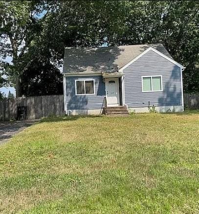 view of front of home with a front yard, entry steps, and fence