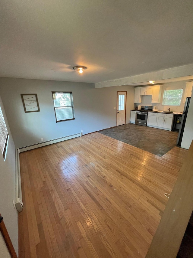 1137 Namdac Ave, Bay Shore, NY 11706 - unfurnished living room with baseboard heating and light wood-style floors