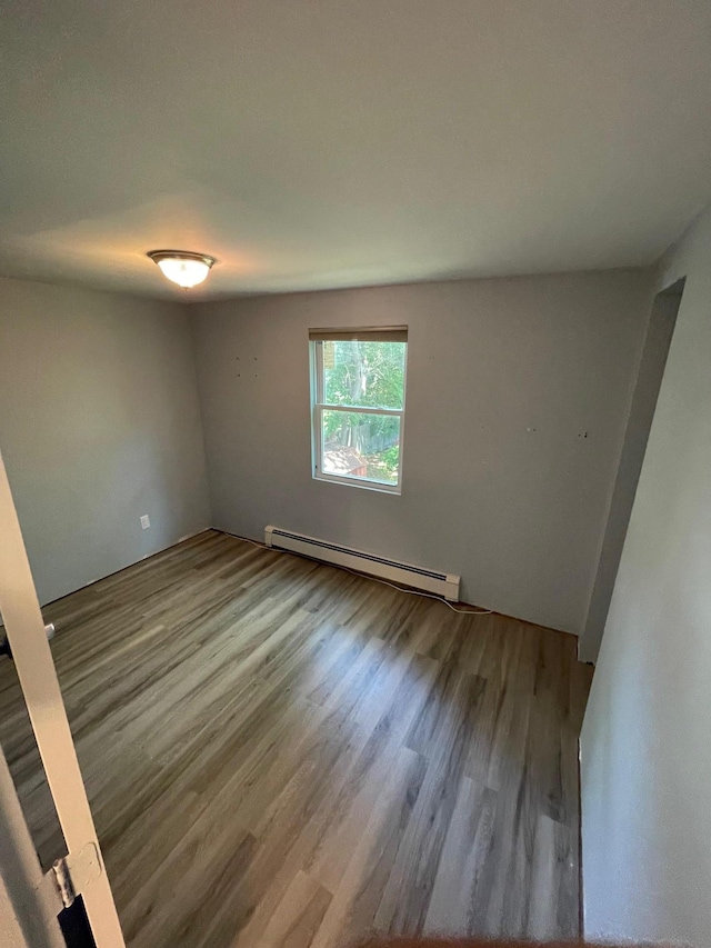 1137 Namdac Ave, Bay Shore, NY 11706 - spare room featuring a baseboard heating unit and wood finished floors
