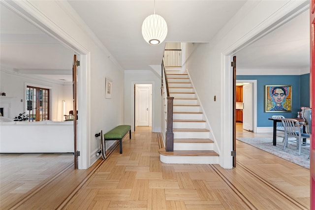 staircase featuring baseboards, ornamental molding, and a fireplace