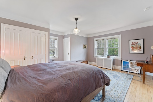 41 Euclid Ave, Hastings-On-Hudson, NY 10706 - bedroom featuring radiator, baseboards, light wood-style floors, ornamental molding, and two closets