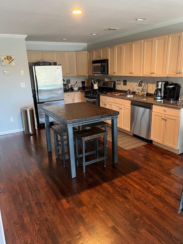kitchen featuring a sink, appliances with stainless steel finishes, dark wood finished floors, crown molding, and decorative backsplash