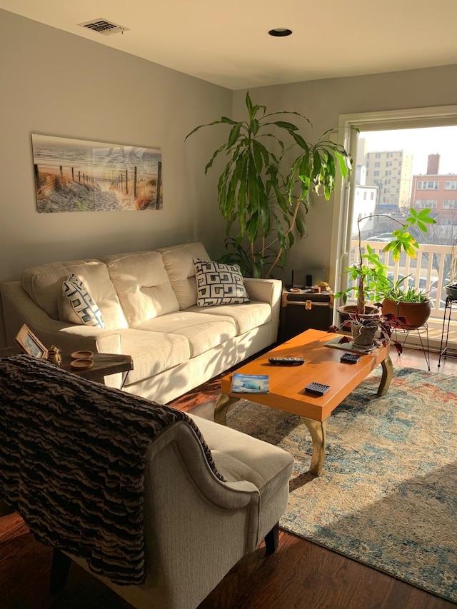 living area with visible vents and wood finished floors
