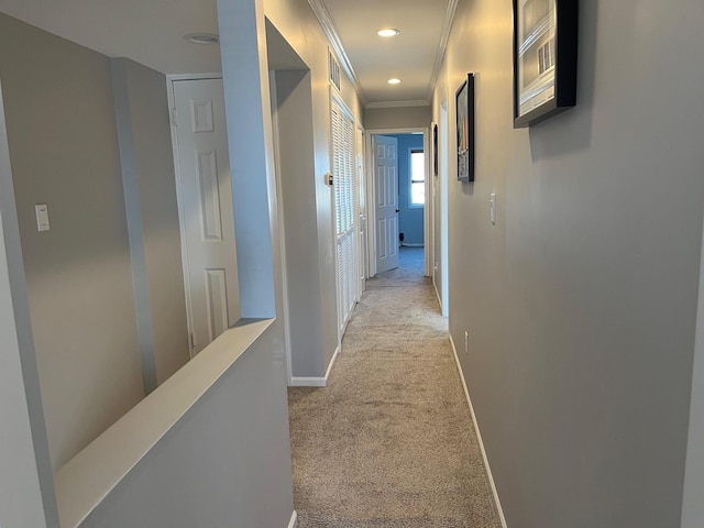 hallway with crown molding, light colored carpet, baseboards, and recessed lighting