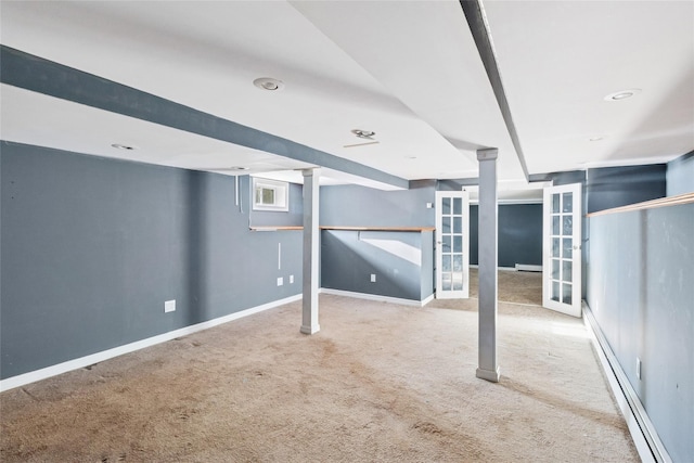 basement with a baseboard heating unit, carpet flooring, and baseboards