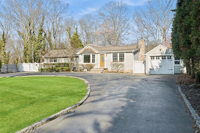 ranch-style house with a garage, aphalt driveway, and fence