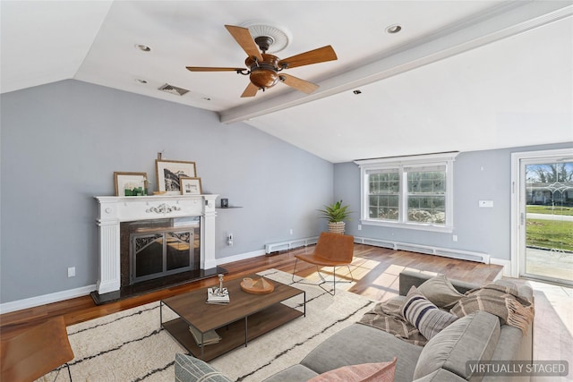 living room featuring visible vents, vaulted ceiling with beams, a fireplace with raised hearth, and a baseboard heating unit