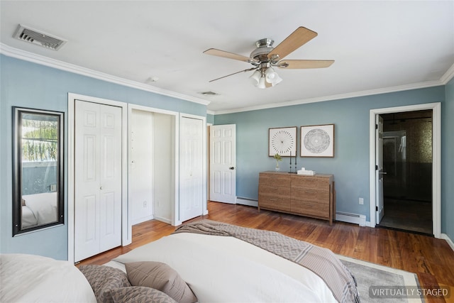 bedroom featuring baseboard heating, crown molding, and visible vents
