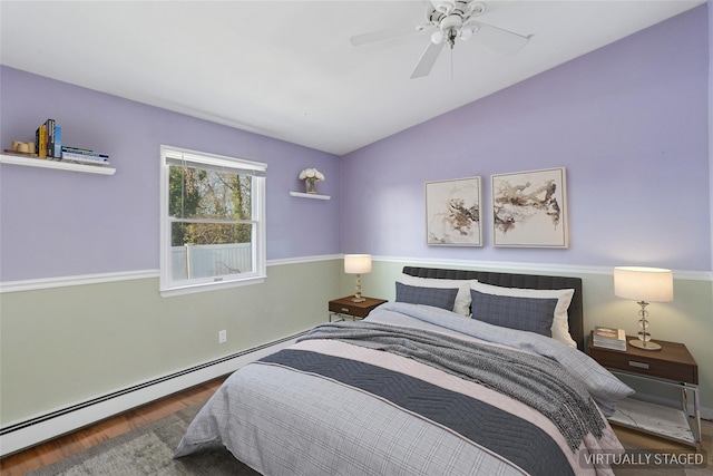 bedroom with ceiling fan, vaulted ceiling, wood finished floors, and baseboard heating