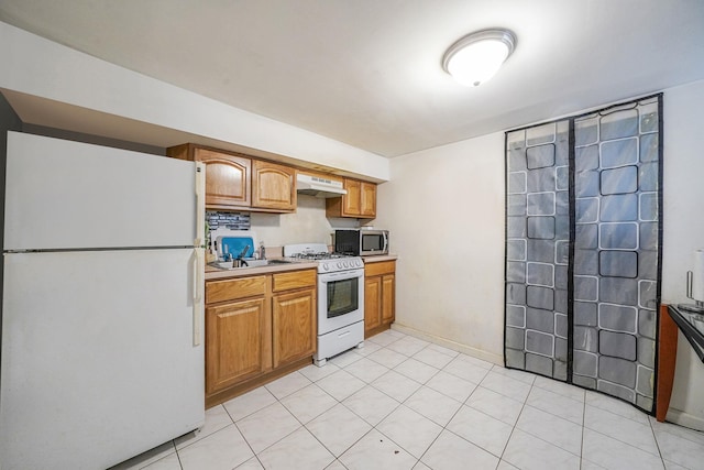 3205 Lafayette Ave, Bronx, NY 10465 - kitchen with under cabinet range hood, white appliances, a sink, and brown cabinetry