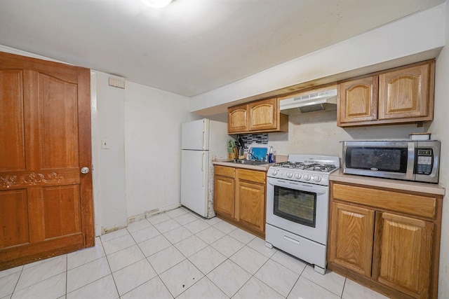 3205 Lafayette Ave, Bronx, NY 10465 - kitchen with light tile patterned floors, light countertops, white appliances, under cabinet range hood, and brown cabinetry