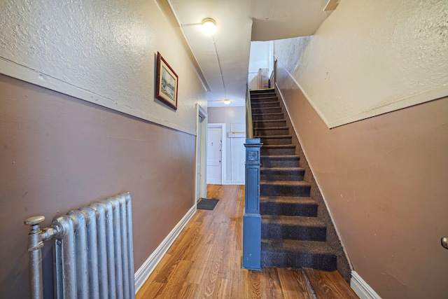 3205 Lafayette Ave, Bronx, NY 10465 - stairs featuring radiator heating unit, baseboards, and wood finished floors
