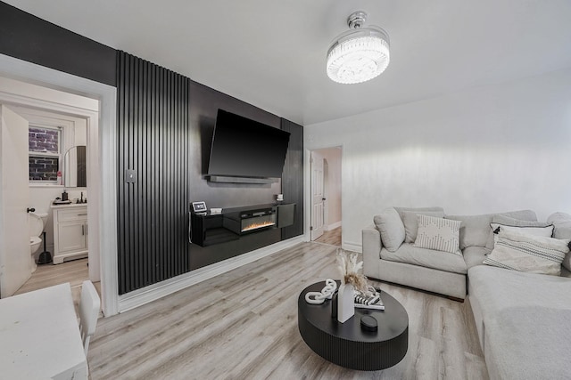 3205 Lafayette Ave, Bronx, NY 10465 - living area featuring a chandelier, a glass covered fireplace, baseboards, and wood finished floors