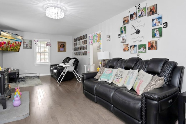 living area featuring baseboard heating, wood finished floors, and a notable chandelier