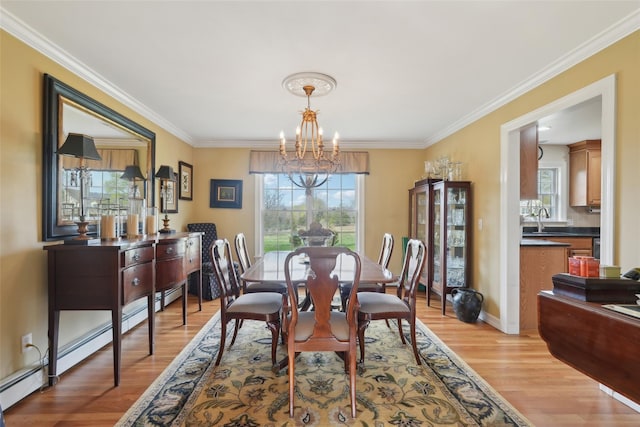 dining room with ornamental molding, a healthy amount of sunlight, a chandelier, and light wood-style floors