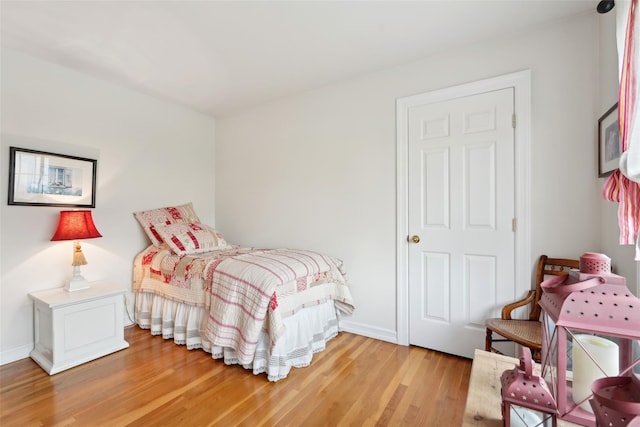 bedroom with light wood finished floors and baseboards