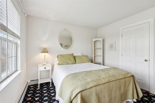 carpeted bedroom with baseboard heating, baseboards, and multiple windows