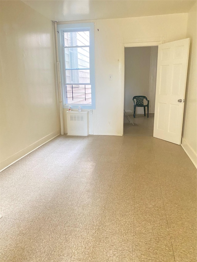 spare room featuring radiator heating unit and baseboards