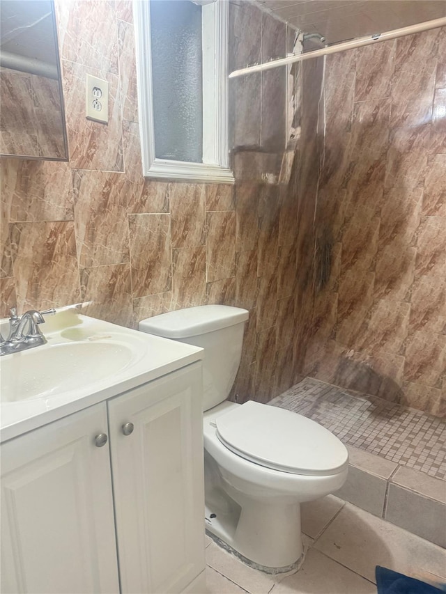 full bathroom with vanity, tile walls, a tile shower, and toilet