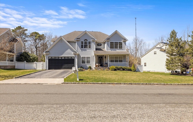 traditional-style home featuring driveway, a front lawn, a porch, a garage, and fence