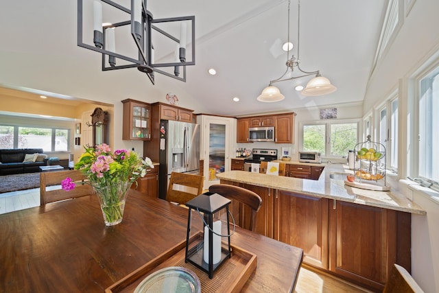 dining space with a wealth of natural light, recessed lighting, a notable chandelier, and vaulted ceiling
