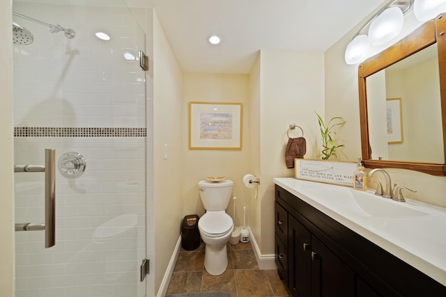 bathroom with a stall shower, vanity, baseboards, and toilet