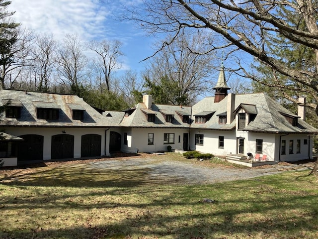 back of property with stucco siding and a lawn