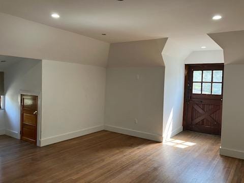 additional living space with recessed lighting, baseboards, vaulted ceiling, and wood finished floors