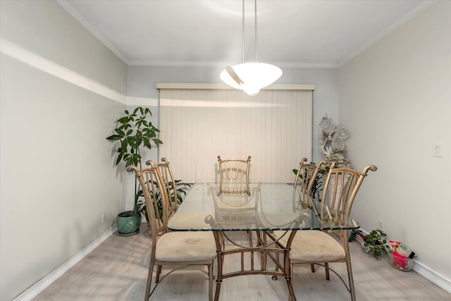 dining area with baseboards, ornamental molding, and wood finished floors