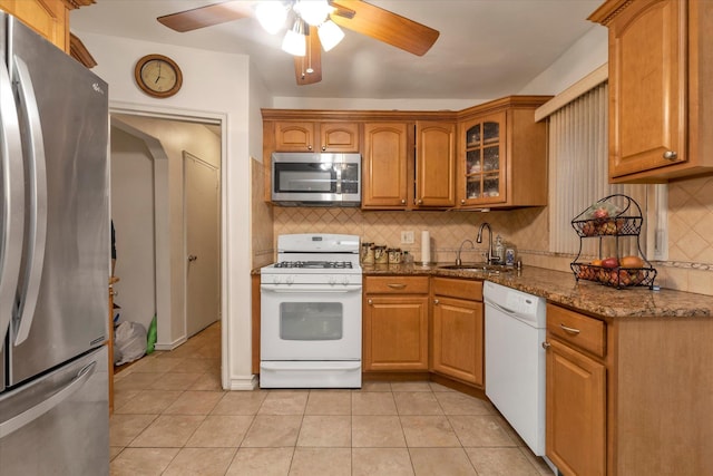 kitchen with ceiling fan, light tile patterned floors, a sink, stainless steel appliances, and backsplash