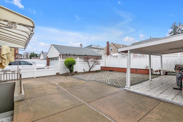view of patio / terrace featuring an outbuilding, a fenced backyard, and a residential view