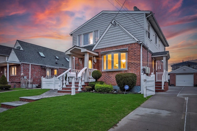 bungalow featuring a front yard, brick siding, a detached garage, concrete driveway, and an outbuilding