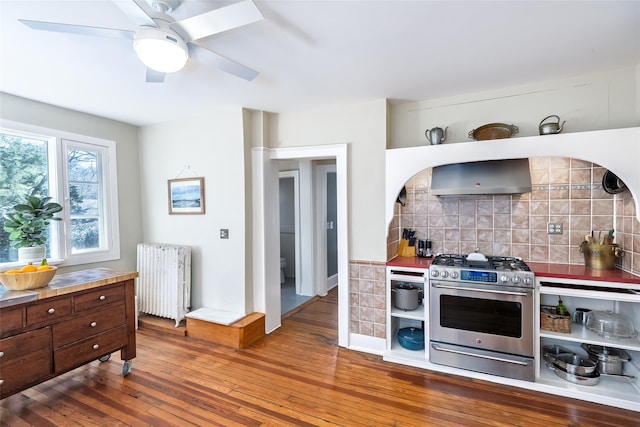 3 Druid Hill Rd, Port Jefferson, NY 11777 - kitchen featuring radiator heating unit, high end stainless steel range, extractor fan, wood-type flooring, and backsplash