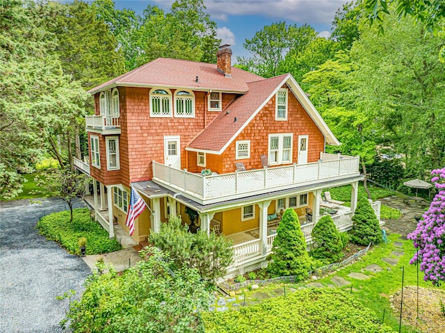 3 Druid Hill Rd, Port Jefferson, NY 11777 - back of house with a chimney, a balcony, driveway, and roof with shingles