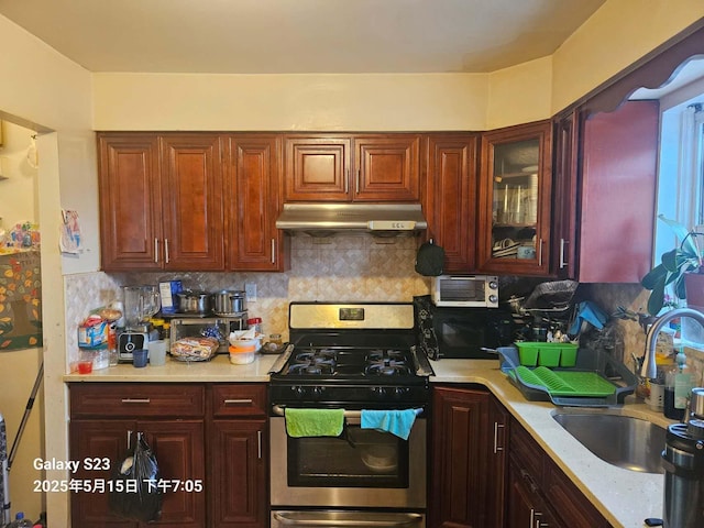 57-12 164th St, Flushing, NY 11365 - kitchen featuring under cabinet range hood, stainless steel gas range, a sink, and tasteful backsplash