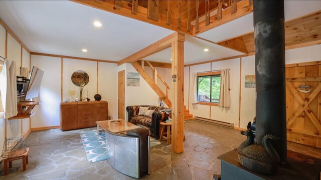 living room featuring a wood stove, stone flooring, a baseboard radiator, and recessed lighting