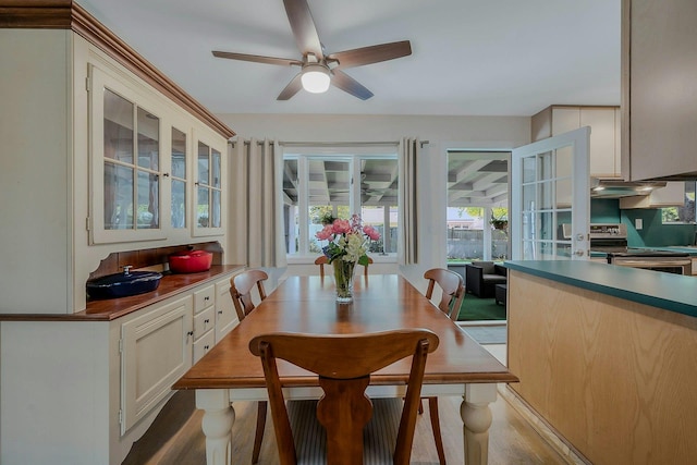 dining room with a ceiling fan, french doors, and wood finished floors