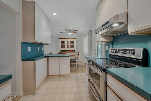 kitchen featuring ceiling fan, double oven range, a peninsula, light floors, and under cabinet range hood
