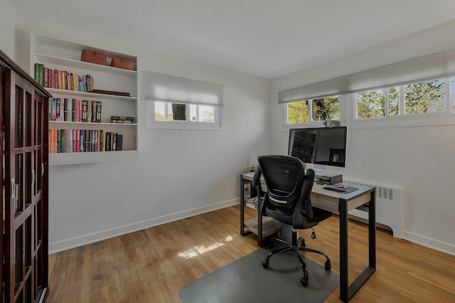 office space featuring radiator, baseboards, and wood finished floors