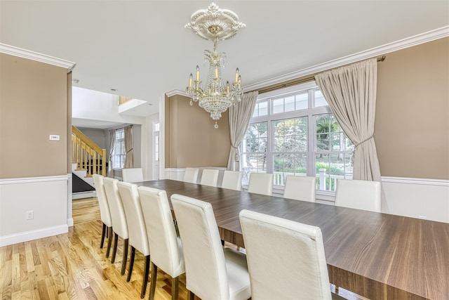 dining room featuring ornamental molding, stairway, wood finished floors, a notable chandelier, and baseboards