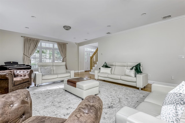 living area with crown molding, visible vents, baseboards, and stairway