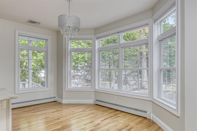 unfurnished sunroom with a notable chandelier, baseboard heating, and visible vents